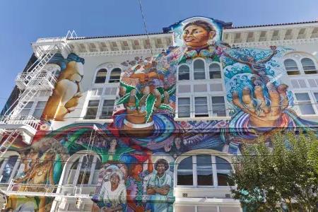 Un murale colorato e di grandi dimensioni copre il lato del Women's Building nel 任务地区 di 贝博体彩app.