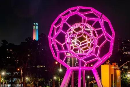 Buckyball shines outside the Exploratorium, with 屁股Tower in the background